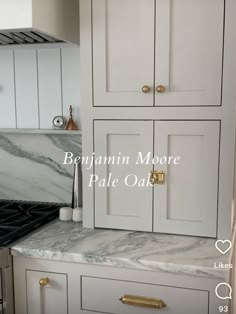 a kitchen with marble counter tops and white cabinets in the corner, next to an oven