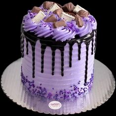 a purple cake with chocolate and candy on top