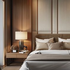 a bed with pillows and lamps on either side of the headboard in a bedroom