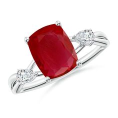 a ring with a red stone and two diamonds on the band, set in white gold