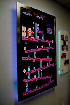 a video game is displayed on the wall next to a neon sign that says super mario