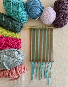 several skeins of yarn sitting on top of a table next to a knitting needle