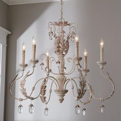 a chandelier hanging from the ceiling in a room with white walls and windows