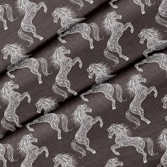 the fabric has horses on it in white and brown colors, as well as an image of