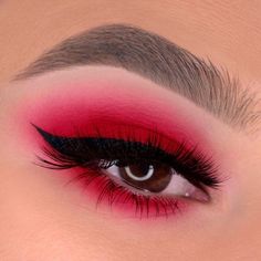 a woman's eye with red and black makeup