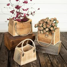 two wooden boxes with flowers in them sitting on a wood table next to each other