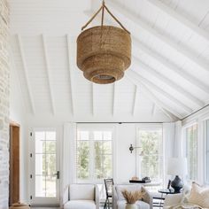 a living room filled with furniture and a large basket hanging from the ceiling above it