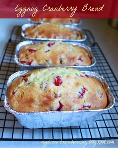 three loafs of strawberry cranberry bread sitting on top of a cooling rack