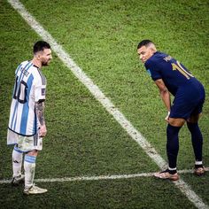 two soccer players standing on the field talking to each other and one is holding his head down