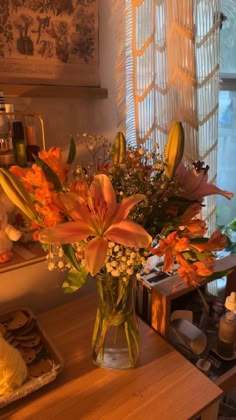 a vase filled with flowers sitting on top of a wooden table next to a window