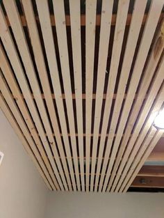 the ceiling is made out of wood planks and has a light on above it