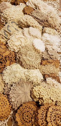 several pieces of crocheted doily laid out on a tablecloth with lace