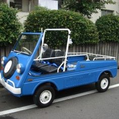 a small blue car parked on the side of the road