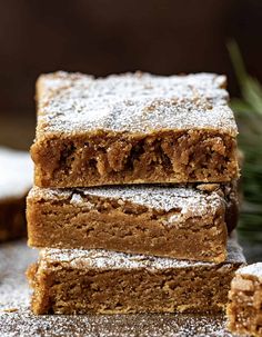 three pieces of brownies stacked on top of each other with powdered sugar around them