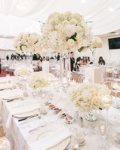 the tables are set with white flowers and candles