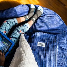 a person laying on a bed using a tablet