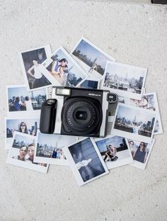 a camera sitting on top of a table covered in photos