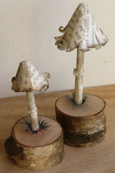 two wooden stumps with plants growing out of them on top of a wood table