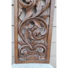 an ornate carved wooden panel on the side of a building