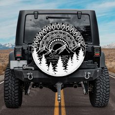 a black and white jeep parked on the side of a road with trees painted on it