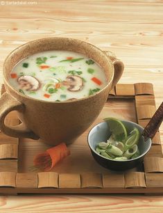 a wooden tray topped with a bowl of soup