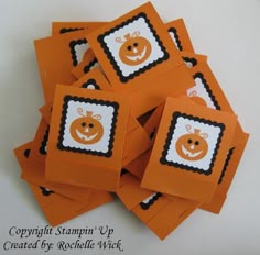 a pile of orange cards with black and white pumpkins on them, sitting next to each other