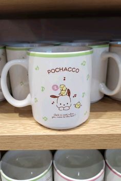 many coffee mugs are on display in a store shelf with the name pochaco printed on them