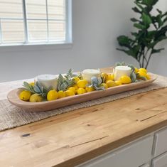 a tray with lemons and candles on top of a counter