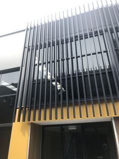 an entrance to a building with metal slats on the outside and yellow painted walls