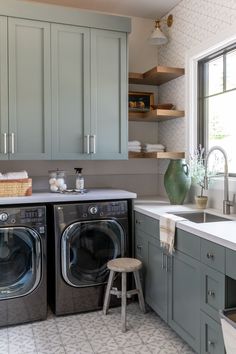 a washer and dryer sitting in a kitchen next to a window with open shelving