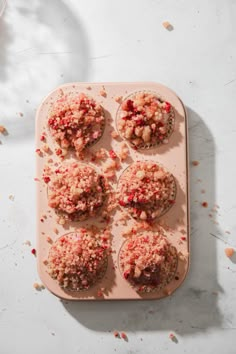 cupcakes with crumbled toppings on a tray