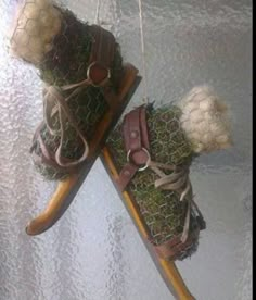 two stuffed animals are hanging from a sled with grass on it's sides