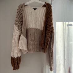 a sweater hanging on a hanger next to a window