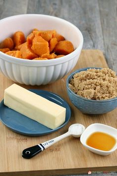 some food is sitting on a cutting board next to a bowl and measuring spoons