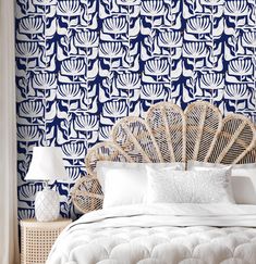 a white bed sitting next to a blue and white wall with a fan on it's headboard