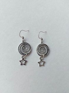 The earrings are decorated with pendants in the shape of a round spiral and a small star. The earrings are fastened with stainless steel hooks. Earring length - 4.0 cm (1.6 inches) Earrings are packed in a gift box RECOMMENDATIONS FOR CARE: Do not wet, do not drop, and store in a dark box! - Remove jewelry before exercising, swimming, showering and sleeping. - Avoid contact with moisture such as make-up, moisturizer, lotion, perfume and hairspray. - Store your jewelry in a box or pouch after use Stars And Spirals, Silver Spiral Earrings, Spiral Goth Earrings, Unique Spiral Silver Earrings, Handmade Spiral Silver Hoop Earrings, Artistic Handmade Spiral Earrings, Spiral Jewelry, Swirl Earrings, Spiral Earrings