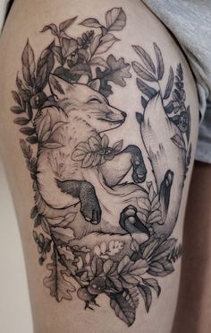 a woman's thigh with an animal and flowers tattoo on her leg, in black and white