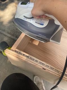 a person using an iron on top of a wooden box