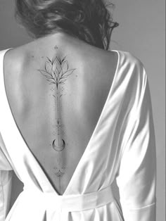 the back of a woman's neck with a flower and moon tattoo on it