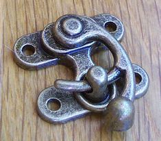 a metal object sitting on top of a wooden table next to a ball and chain