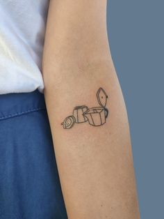 a person with a tattoo on their arm has a toilet paper roll in the shape of a motorbike