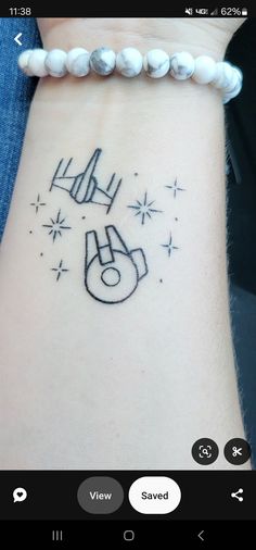 a tattoo on the wrist that has a star wars symbol