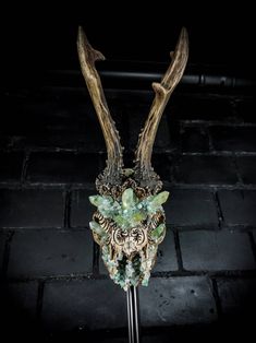 a close up of a metal object with horns and beads on it's head