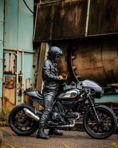 a man in black leathers is sitting on a motorcycle