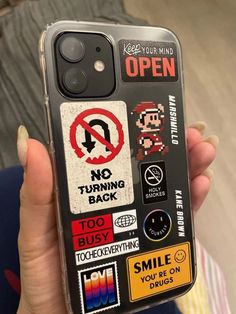 a person holding up a phone case with stickers on it that says no turning back