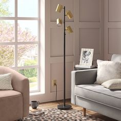 a living room scene with focus on the floor lamp and sofa in front of the window