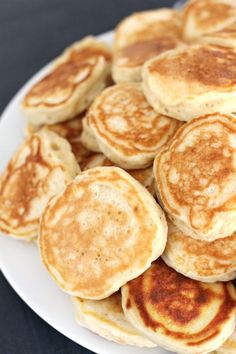 some pancakes on a white plate sitting on a table