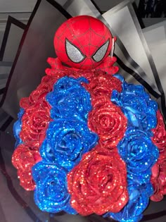 a spider - man bouquet made out of red, blue and pink roses is on display