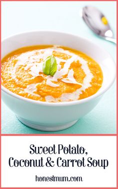 a bowl of sweet potato, coconut and carrot soup on a blue table with spoons