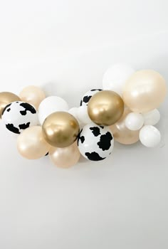 a bunch of balloons that are in the shape of cow's and black spots